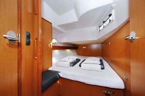 Una cabaña compacta con cama, un espacio de descanso pequeño y techo con lámpara.