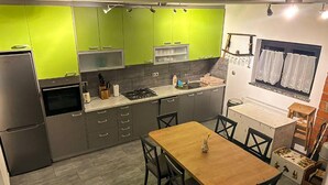 Een koffiezetapparaat/waterkoker, een koelkast, een oven, een kookplaat