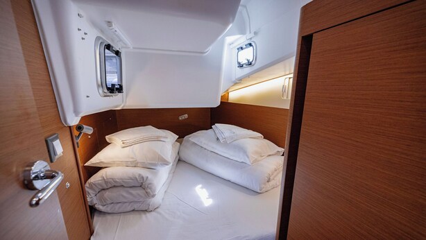 A compact, well-lit cabin with a single bed, a small window, and a wooden door. - Sun-Kissed Sailing Adventure in Split, Croatia (Kaštel Gomilica)