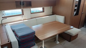 Une petite cuisine équipée avec une table en bois, des sièges en forme de banc et une petite fenêtre.