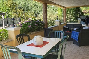 An outdoor patio with a table, chairs, a coffee pot, and a grill area. - Ground Floor of a Villa for Rent for a Dream Vacation in a Peaceful Natural Setting (Les Adrets-de-l'Estérel)