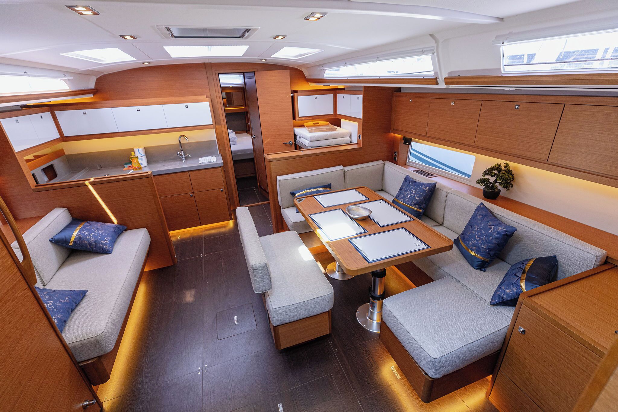 A compact, well-lit interior with a kitchenette, seating area, and a small sleeping berth.