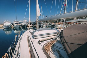 A marina with multiple boats docked, ropes tied to the boats, and a clear blue sky. - Sun-Kissed Sailing Adventure in Split, Croatia (Kaštel Gomilica)