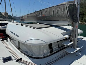 A sailboat with a covered deck area, a cabin with windows, and a mast. - Dubrovnik Delight: A Sun-Kissed Sailing Experience (Komolac)