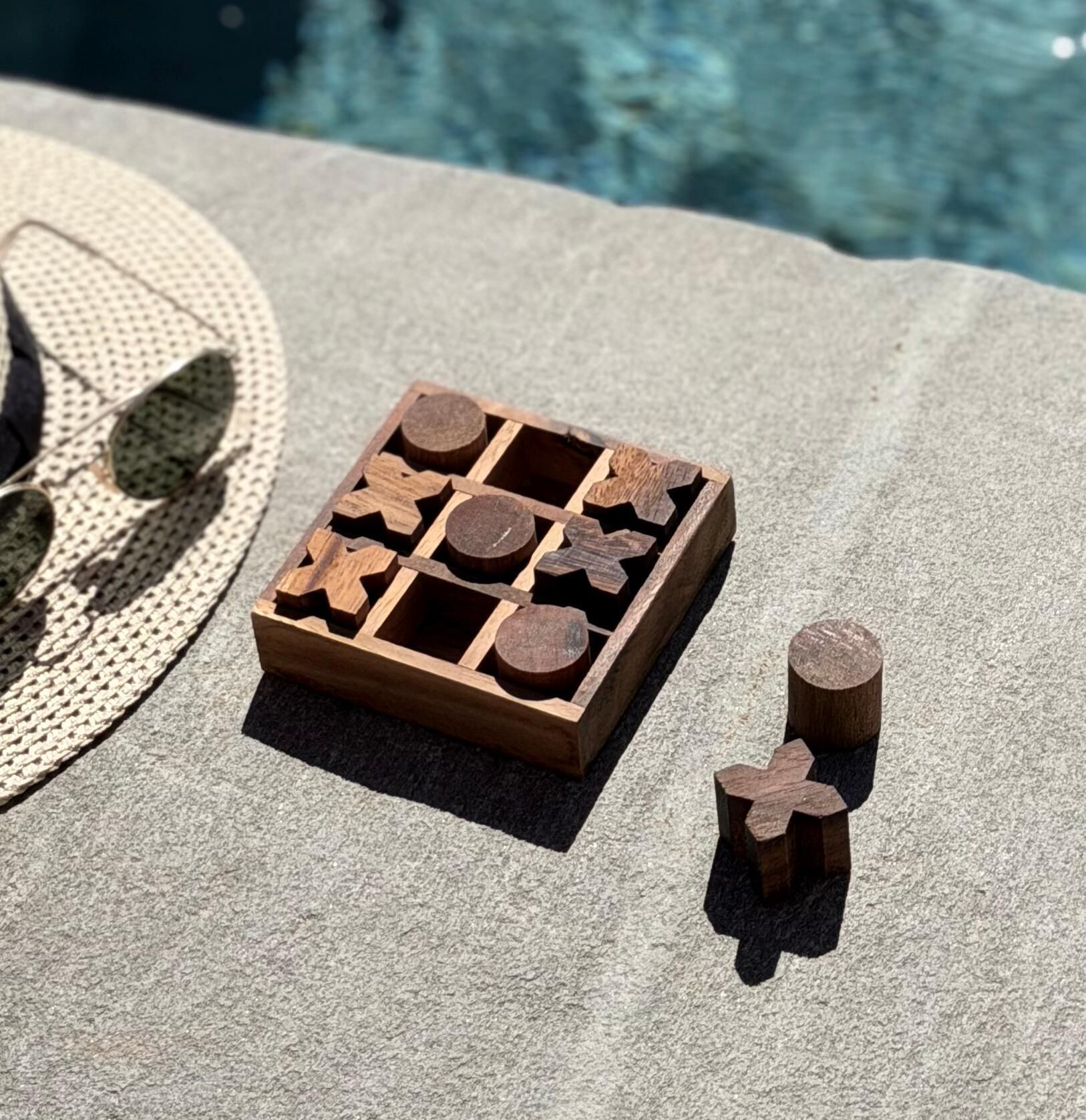 A wooden puzzle box with cut-out shapes on a textured fabric surface.