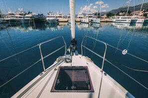 Un port de plaisance où sont amarrés de nombreux bateaux, un ciel dégagé et une eau calme.