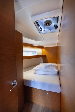 Ein gemütliches Blockhaus mit Etagenbett, Dachfenster und Holztür.