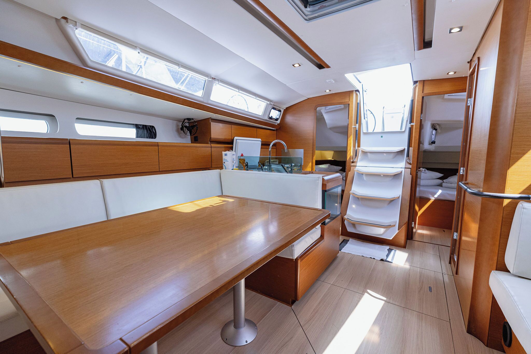 A compact kitchen with a wooden table, built-in cabinets, and a window.