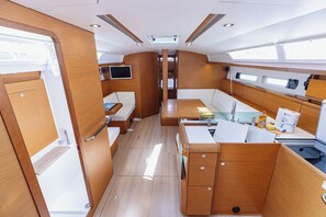 A compact galley with a sink, stove, and seating area. - Sun-Kissed Sailing Adventure in Split, Croatia (Kaštel Gomilica)