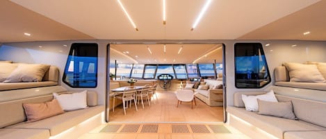 A modern interior with a central dining area, sofas, and large windows.