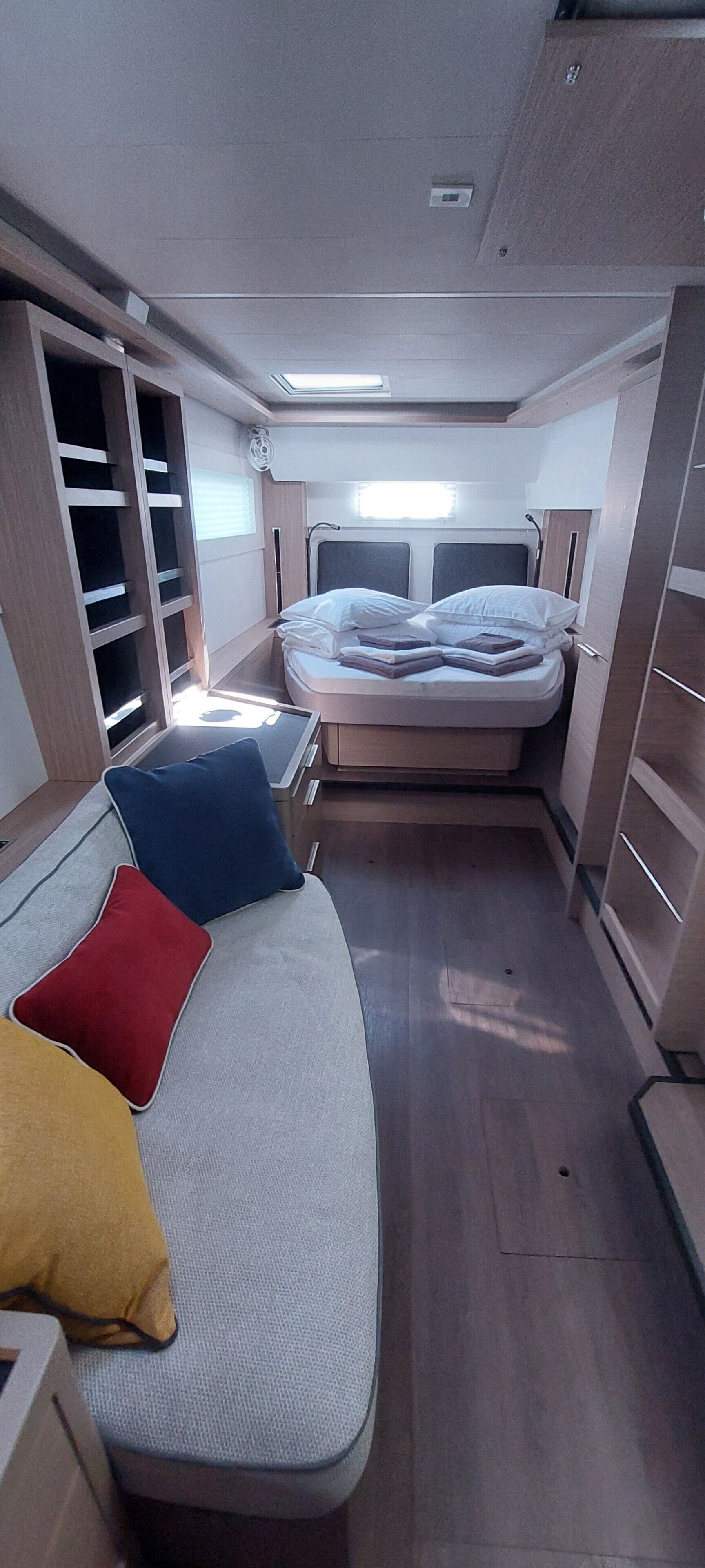 A compact bedroom with a bed, a small seating area, and a wardrobe.