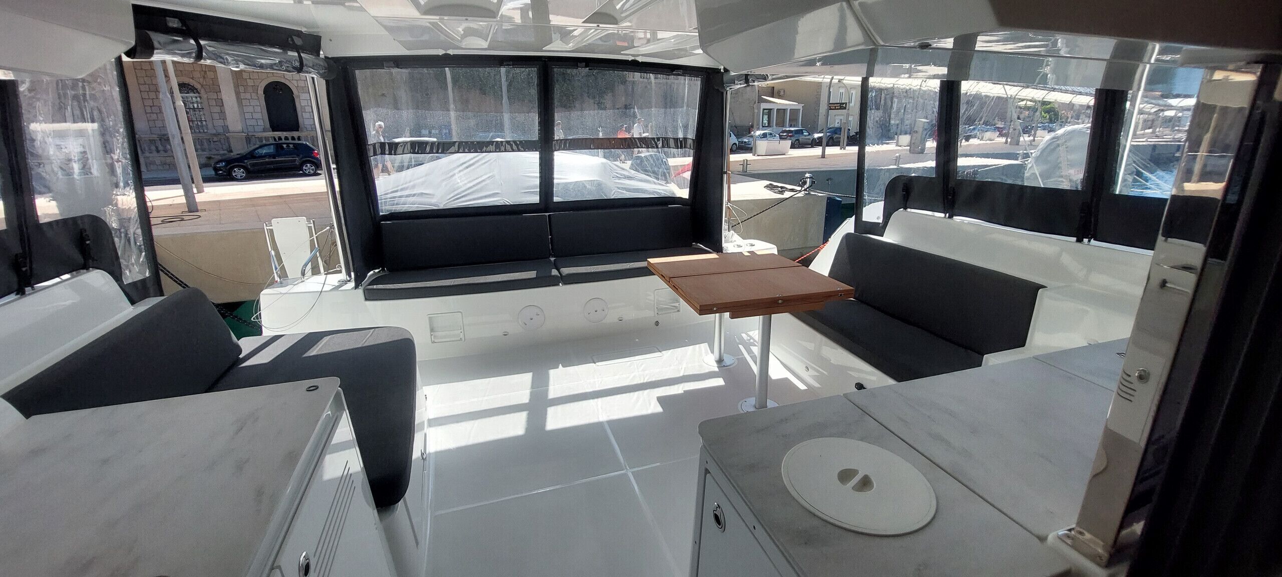 L'intérieur d'un bateau, avec un espace salon, une table et une vue sur l'extérieur.