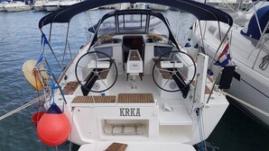 Um barco com cabine, uma placa com o nome 'KRKA' e deck de madeira.
