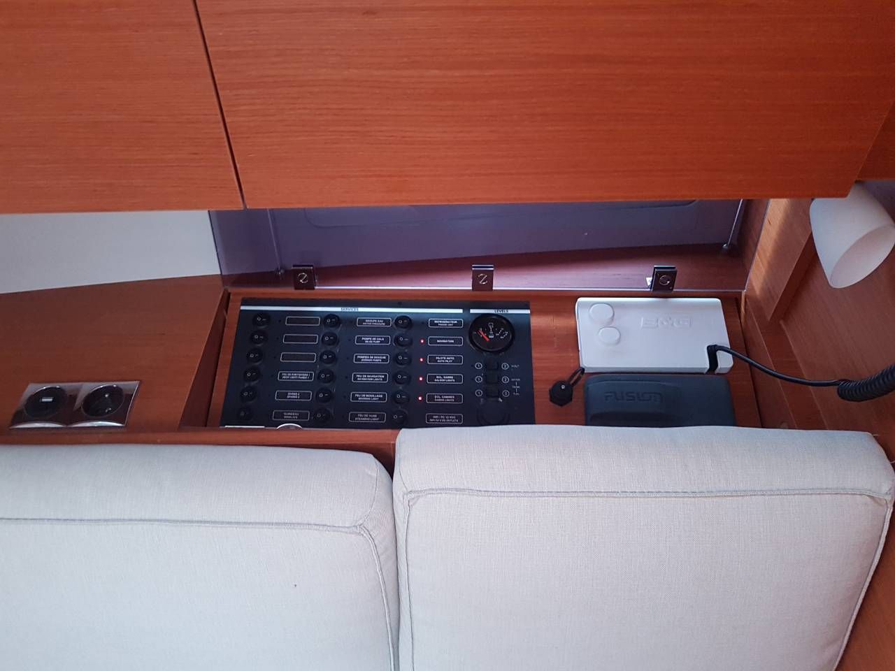 A compact control panel with various switches and a gauge, a small white device, and a power outlet.