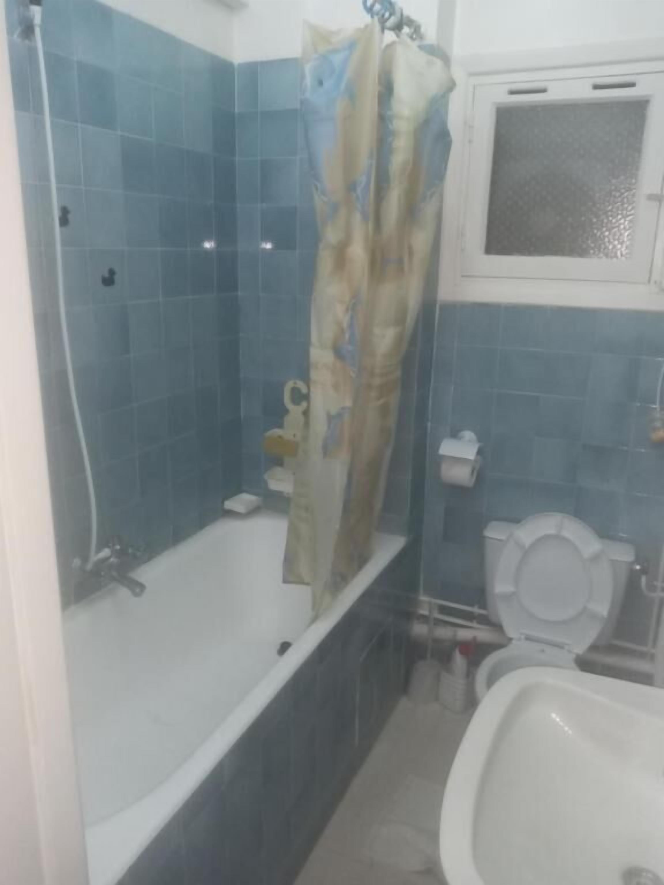 Un baño con bañera, inodoro y cortina de ducha.