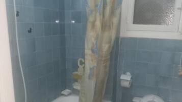 Un baño con bañera, inodoro y cortina de ducha.