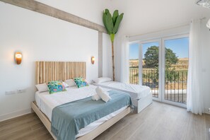 A bedroom with a bed, a large window, and a view of the outdoors.