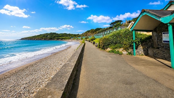 A coastal walkway with a stone wall, beach, and seaside buildings. - The Mews - 1 Bed Holiday Home - Langland (Swansea)