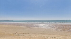 A beach with a clear sky, calm sea, and distant landforms. - 40 Meridian Tower - 1 Bedroom Apartment - Swansea (Swansea)