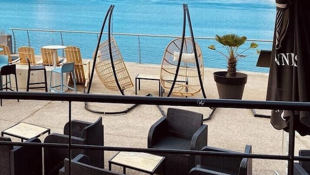 A terrace with wicker furniture, a hanging chair, and a potted plant. - Family home with a veranda and large garden, 7 min from the beaches by Groom* (Guidel)