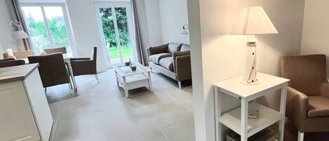 A modern living room with a sofa, a coffee table, a lamp, and a television on a stand.