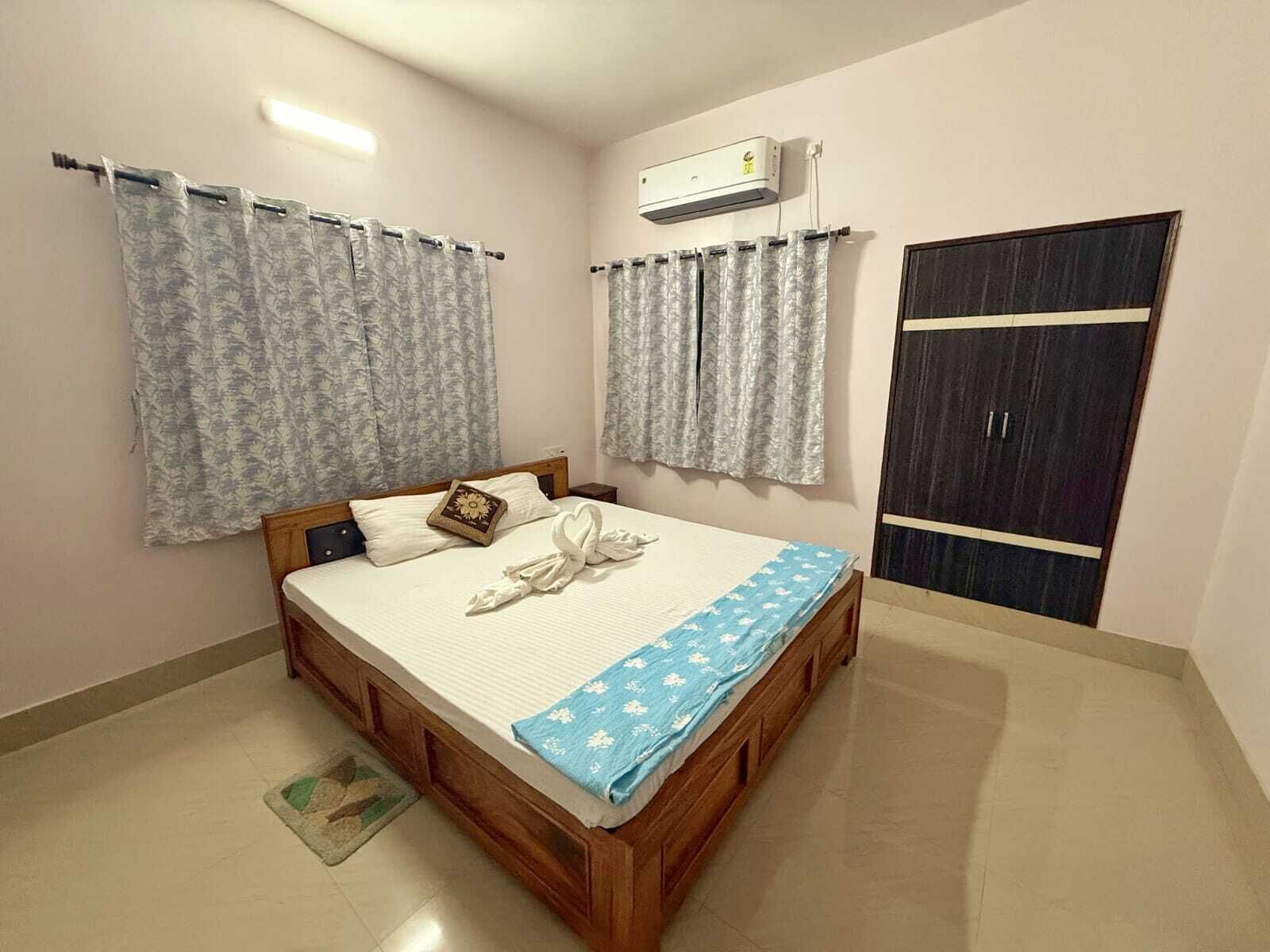 Een slaapkamer met een bed, gordijnen, een airconditioning en een kledingkast.