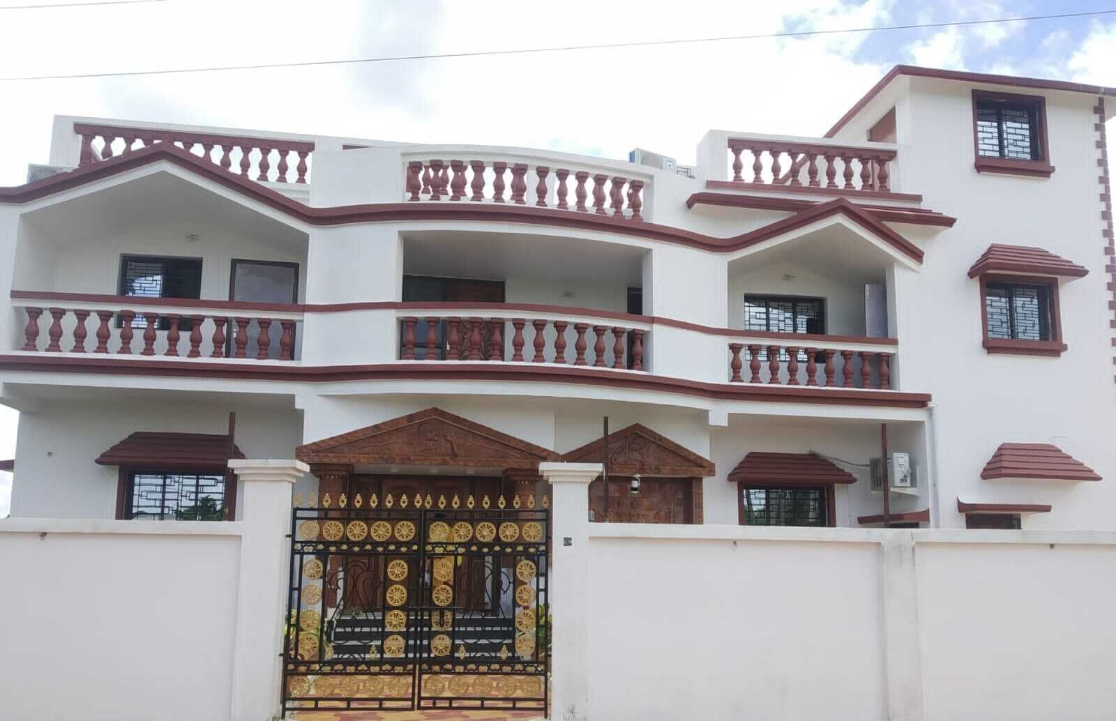 Un edificio residenziale a più piani con balconi, un cancello decorativo e una facciata bianca.