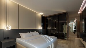 Un dormitorio moderno con una cama grande, mesitas de noche, un vestidor y un baño con espejo.