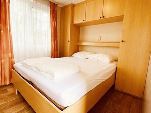 Ein Einzelbett mit Holz Kopfteil und Holzboden.