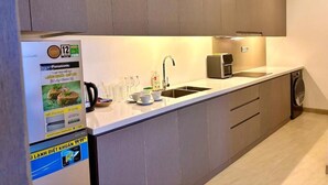 A modern kitchen with a built-in dishwasher, a sink, and a microwave. - Golden Bay 2 Bedrooms Apartment (Da Nang)