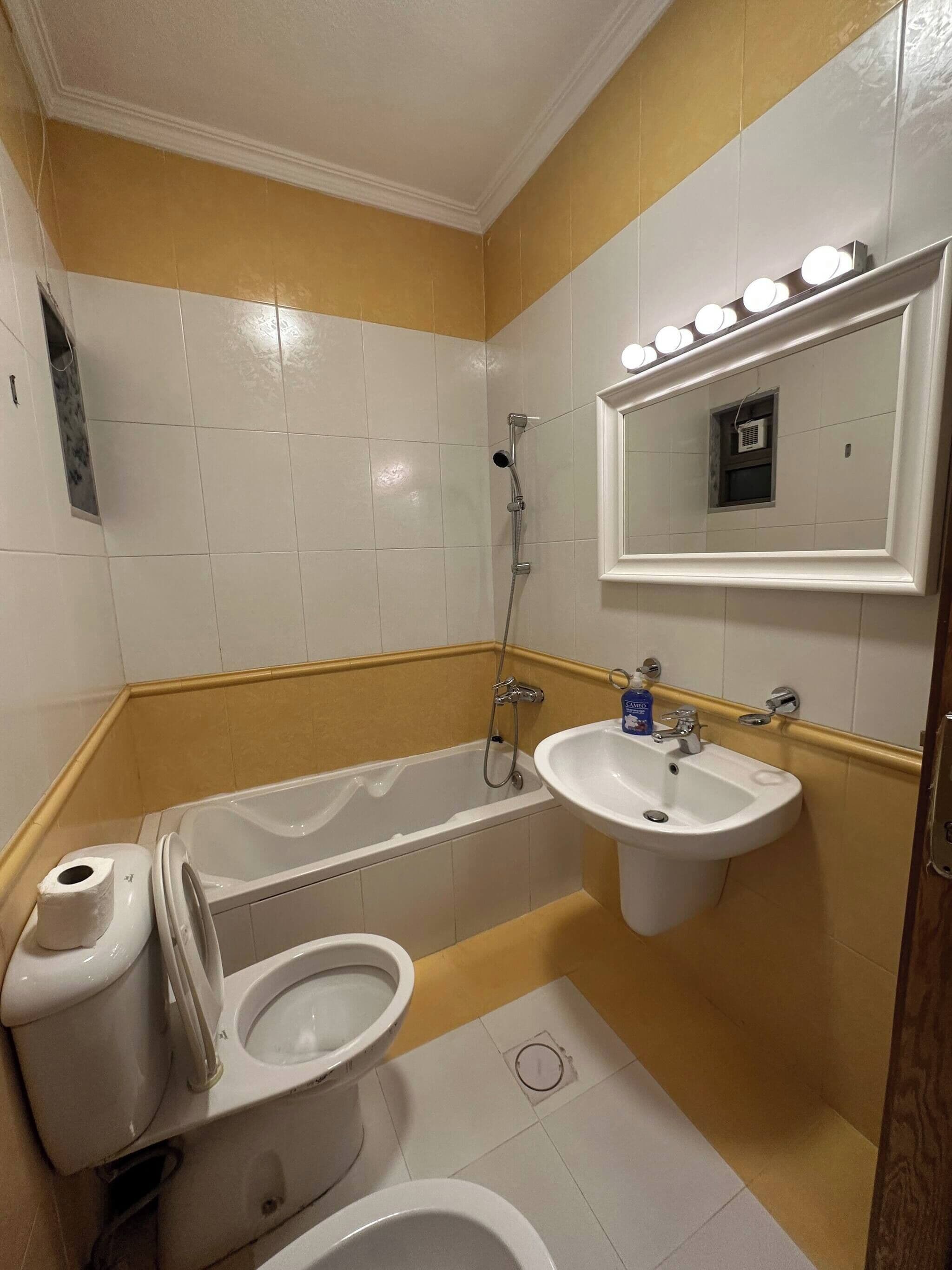 Ein Badezimmer mit Badewanne, Toilette, Waschbecken und Spiegel.