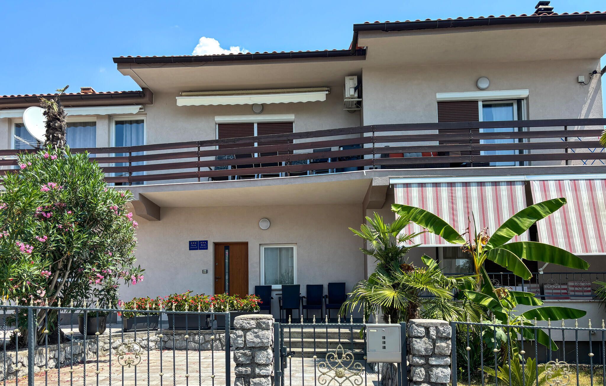 A two-story building with a balcony, a door, and a window.