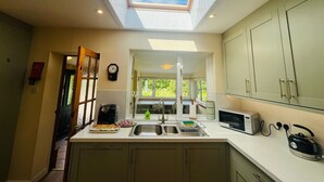 A kitchen with a skylight, a microwave, a sink, and cabinets. - Coire Breac near Roy Bridge (Inverroy)