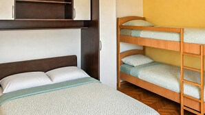 A bunk bed with a wooden frame and a single bed with a headboard. - Nice apartment in Mimice with WiFi (Mimice)