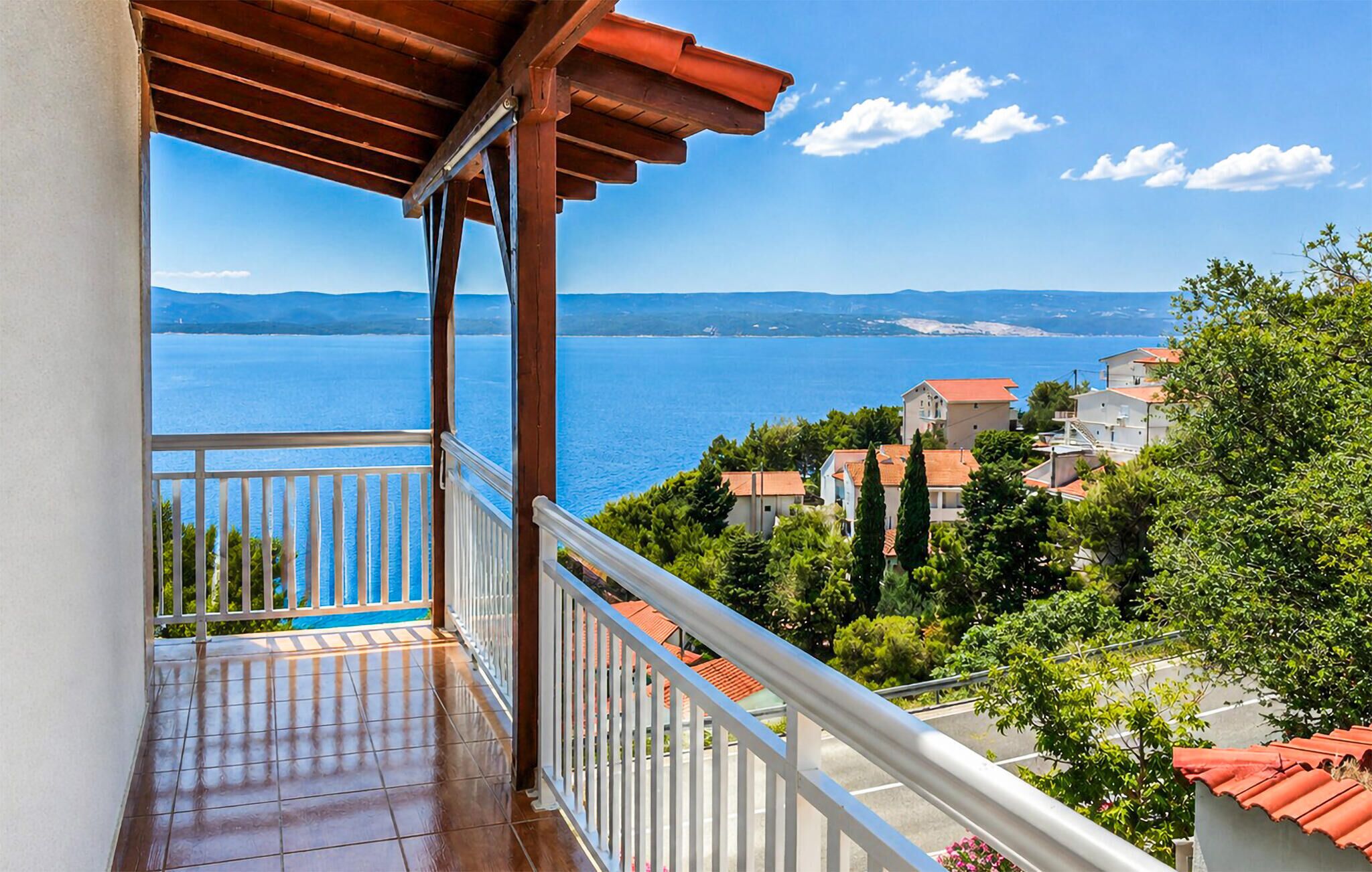A balcony with a view of a coastal town and the sea.