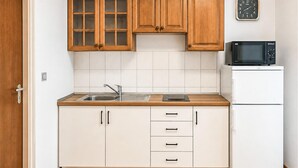 A kitchen with white cabinets, a stainless steel sink, a microwave, and a refrigerator. - Nice apartment in Mimice with WiFi (Mimice)