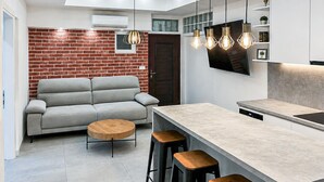 Une cuisine moderne avec un canapé, une table ronde en bois et des tabourets de bar.