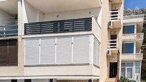 A multi-story building with balconies, a flat roof, and a clear sky. - Lovely apartment in Mimice with WiFi (Mimice)