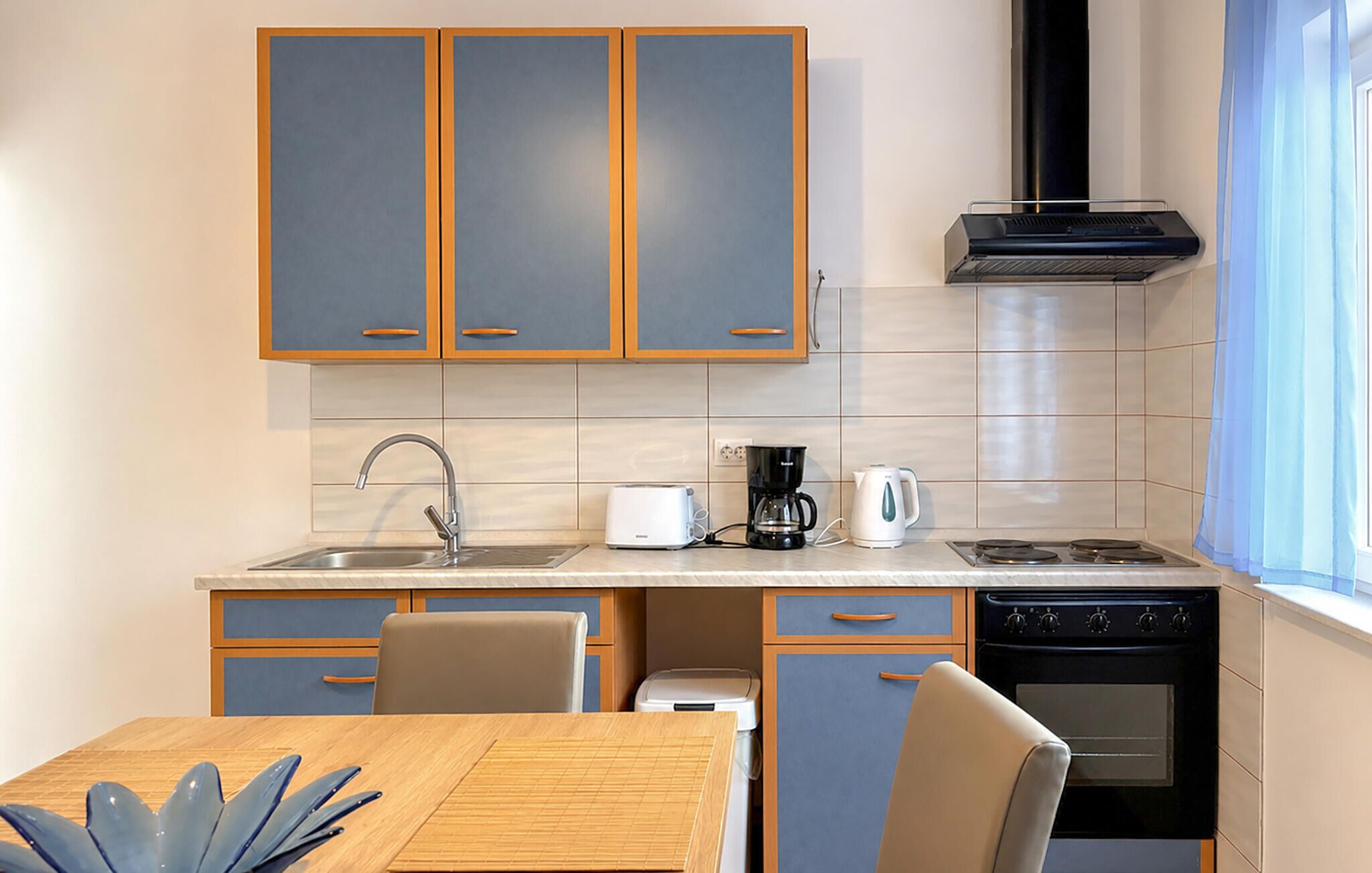 Una cocina moderna con horno empotrado, cafetera y tostadora.