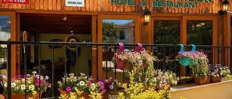 A wooden building with a sign reading 'Secret Garden Hotel & Restaurant.'