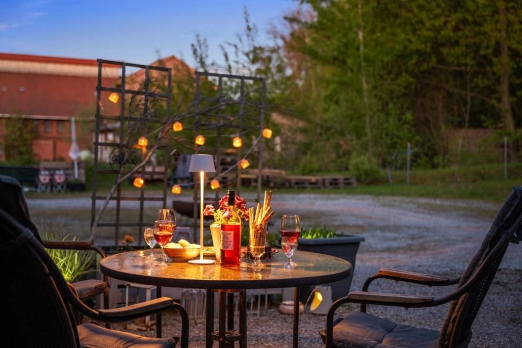 An outdoor dining area with a round table, chairs, and string lights.