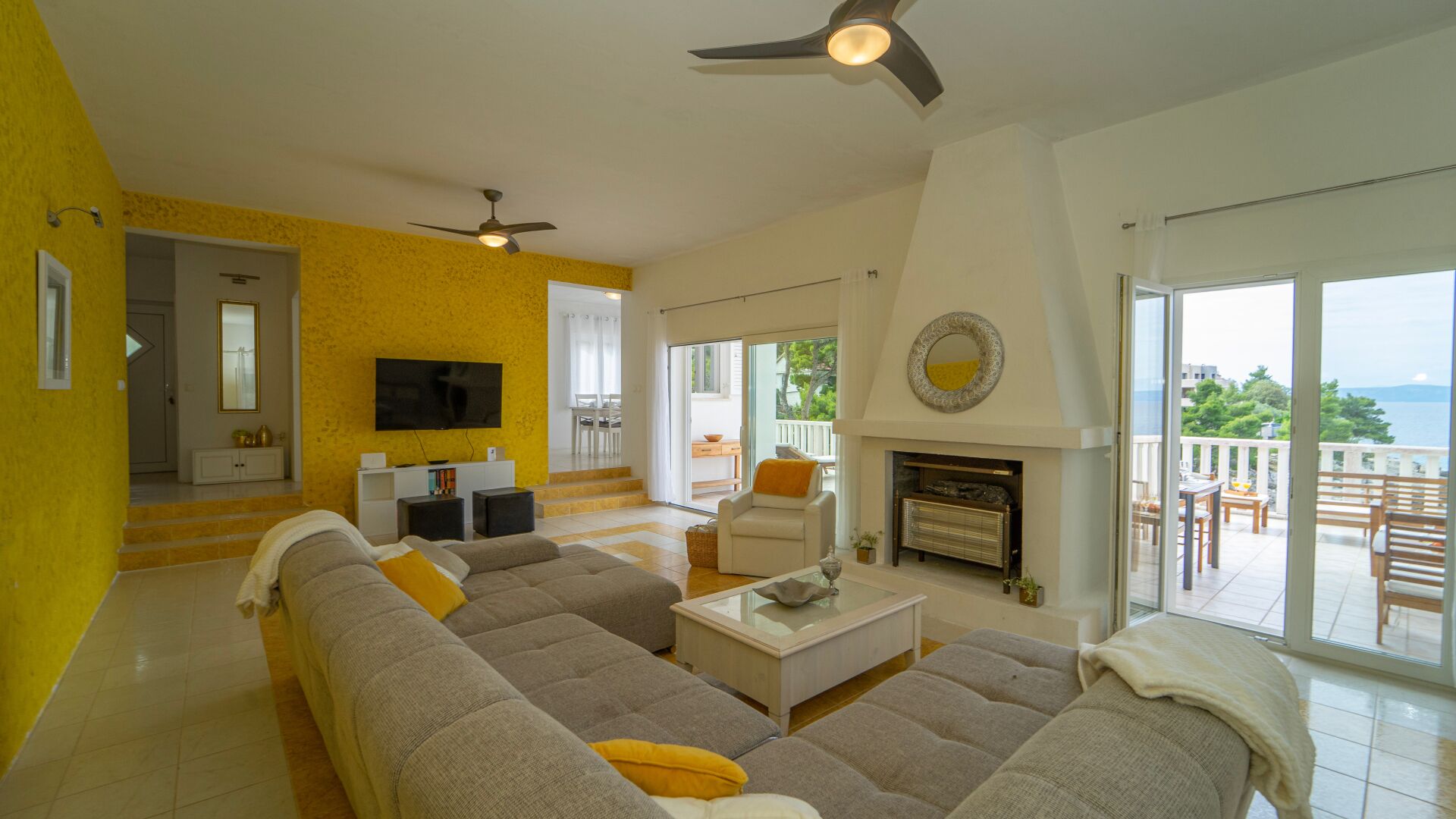 A living room with a sofa, television, and fireplace.