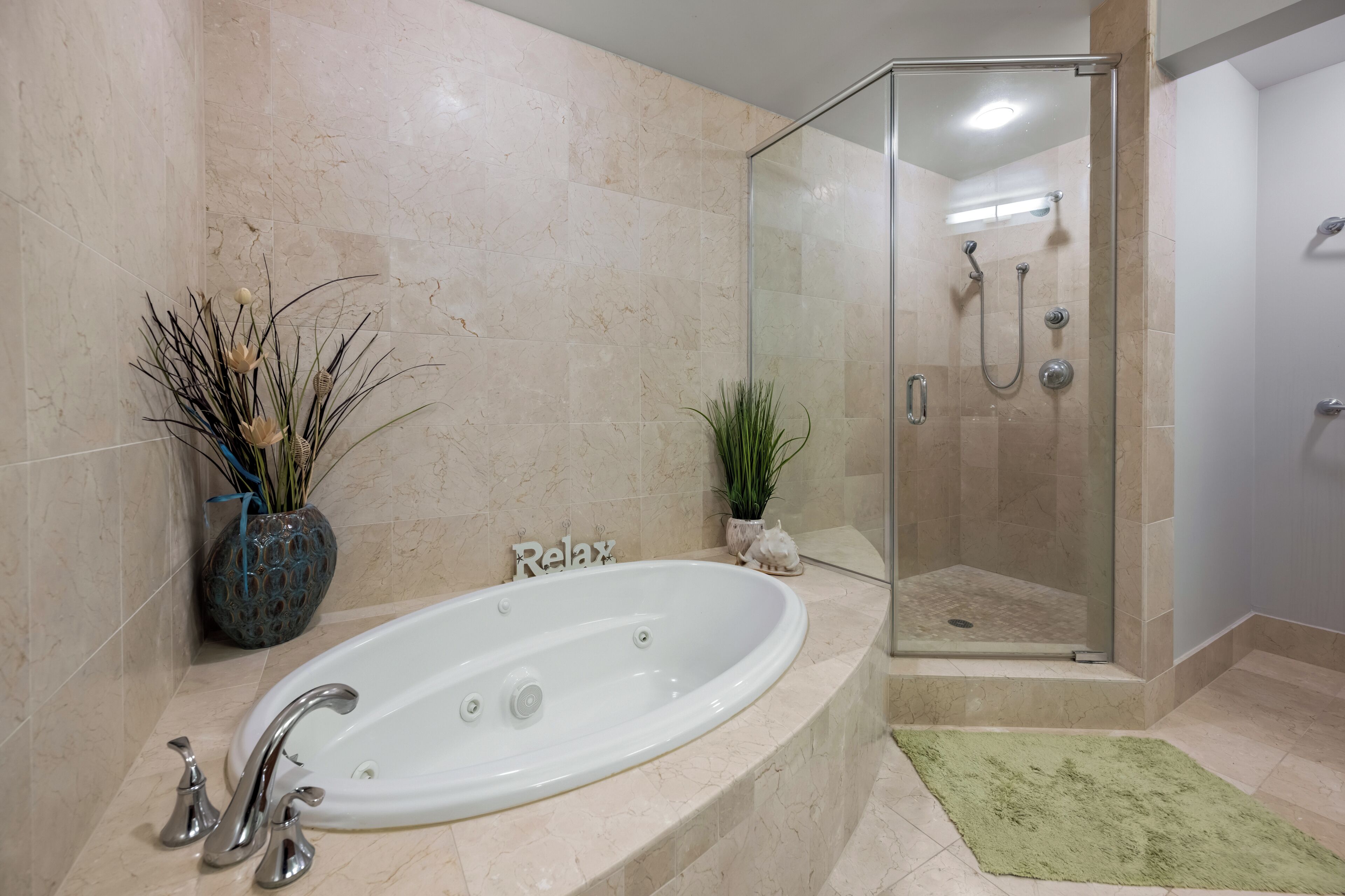 A bathroom with a bathtub, shower, and a glass-enclosed shower stall.