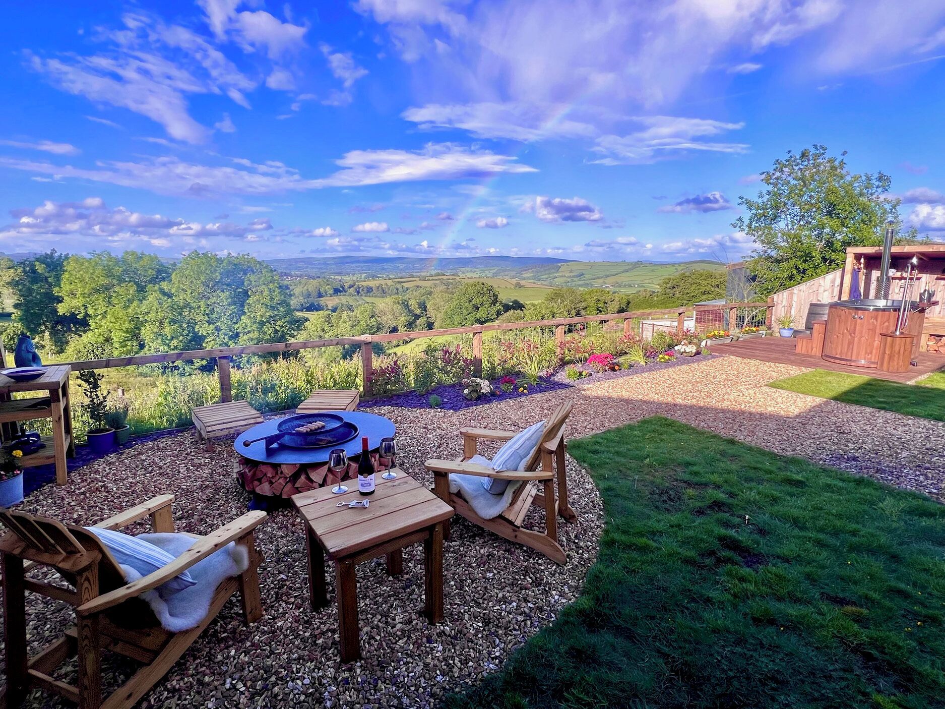 Une terrasse avec une table ronde, des chaises et un barbecue.
