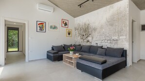 A modern living room with a grey sofa, a coffee table, and artwork on the walls. - Villa Bateli by Villas Guide (Barban)