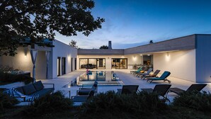 A modern house with a swimming pool, outdoor seating, and a kitchen area. - Villa Bateli by Villas Guide (Barban)