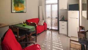 A compact living space with a dining area, a kitchenette, and a sliding glass door leading to a balcony. - Casa Chiara - In the Heart of Authentic Abruzzo (San Martino)