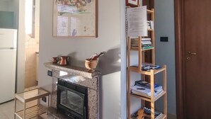 A kitchen with a built-in oven, a wooden shelf with books, and a framed artwork on the wall. - Casa Chiara - In the Heart of Authentic Abruzzo (San Martino)
