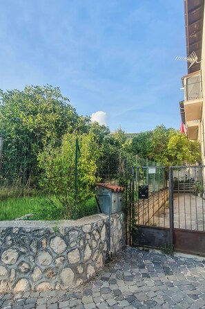 Eine Steinsäule, ein Metallgitter und ein Gebäude mit einem Balkon.