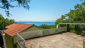 A terrace with a view of the sea, a small building with a tiled roof, and a satellite dish. - Holiday home Batida Crikvenica by Villas Guide (Crikvenica)